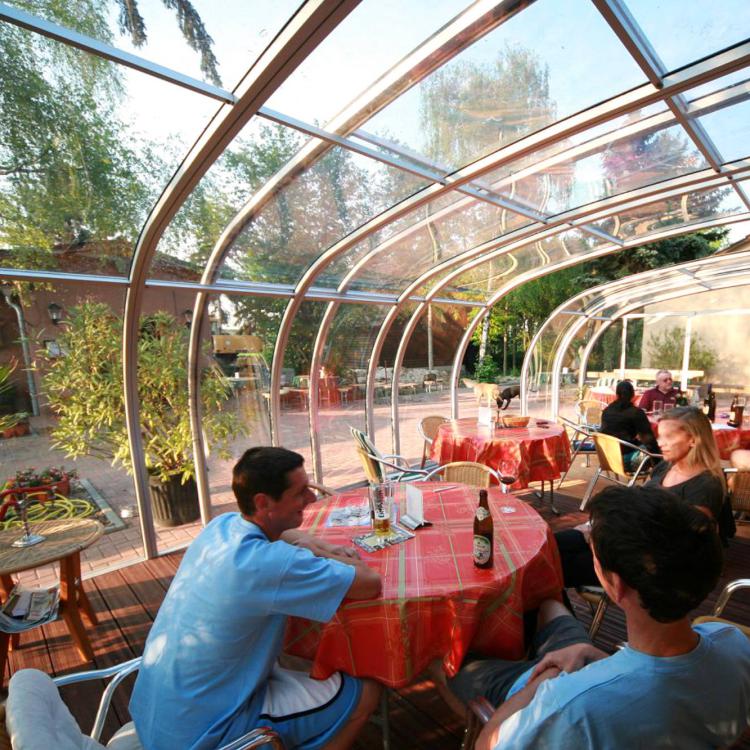 Abri de terrasse télescopique et terrasse de bar en bois
										