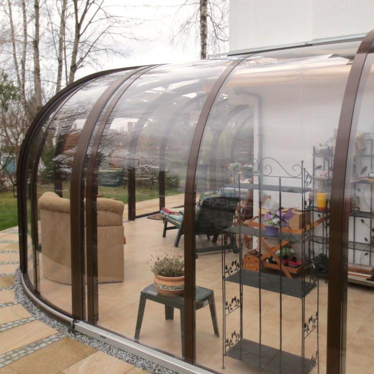 Abri de terrasse avec quart de rotonde pour habiller l'angle de la maison
										